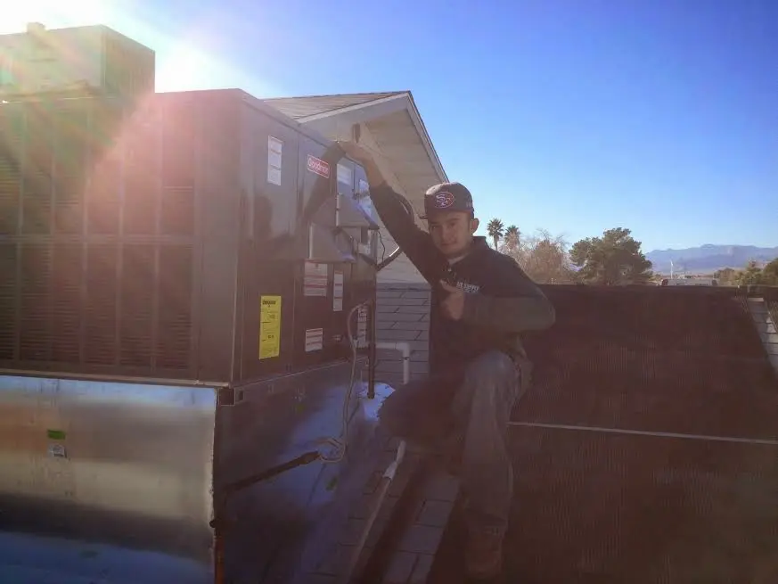 HVAC technician performing Air Duct Cleaning on a rooftop unit in Starke